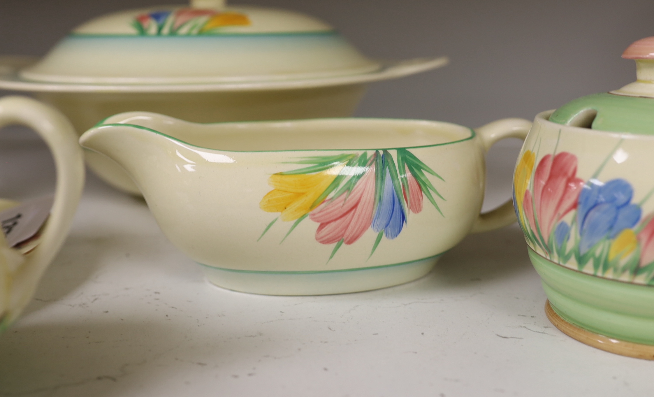 Clarice Cliff ‘Spring Crocus’: a tureen and cover, a cup and saucer, two jam pots, a sauce boat and cream jug (7)